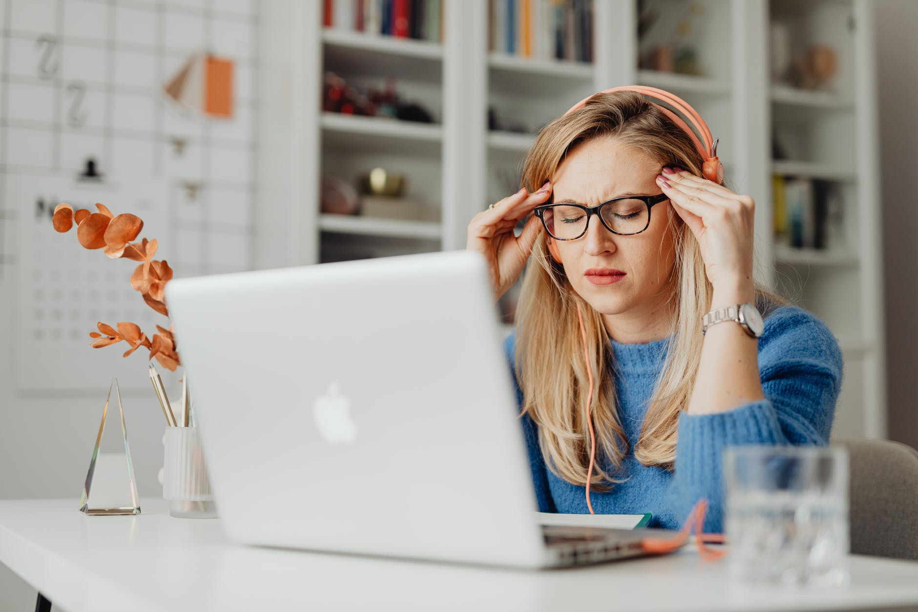 woman in blue shirt using macbook